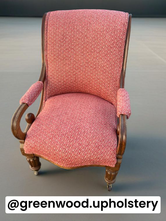 Victorian scroll-arm library chair in a red diamond weave.