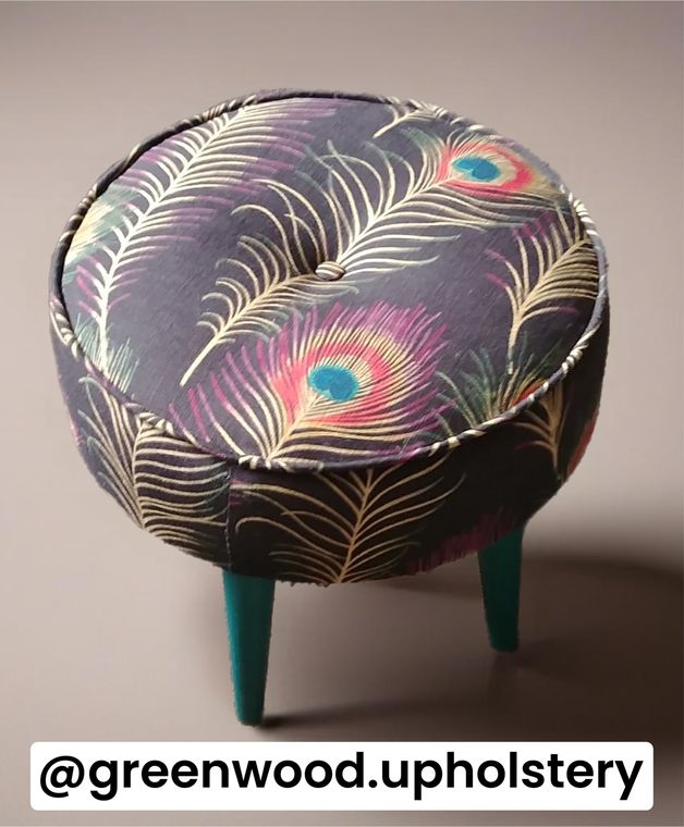 Round button footstool in a peacock-feather print.