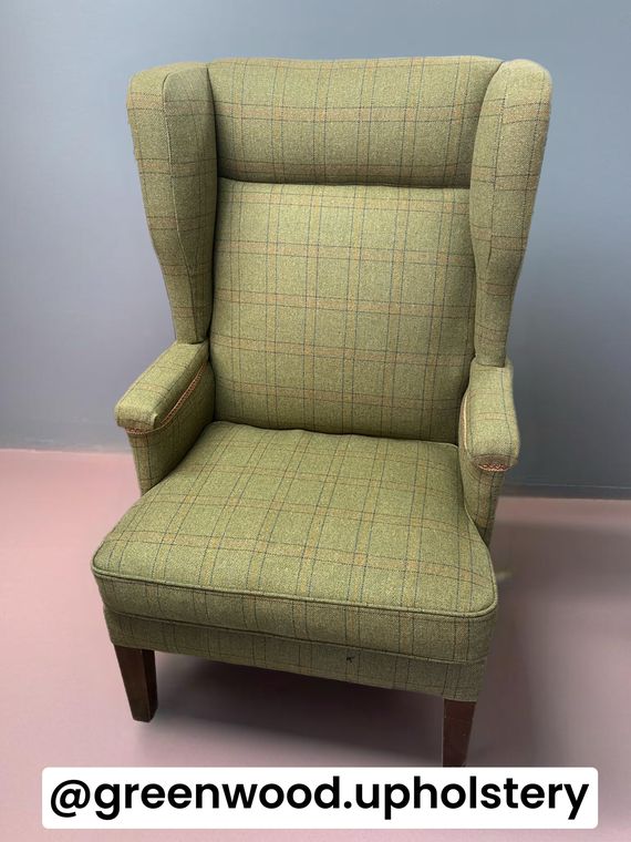Tall wing-back armchair in green windowpane tweed with braid.