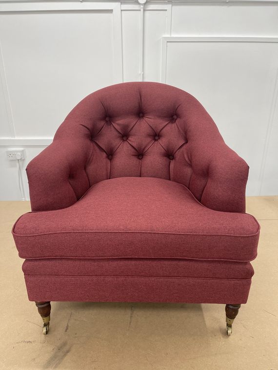 Deep-buttoned tub chair in raspberry wool.
