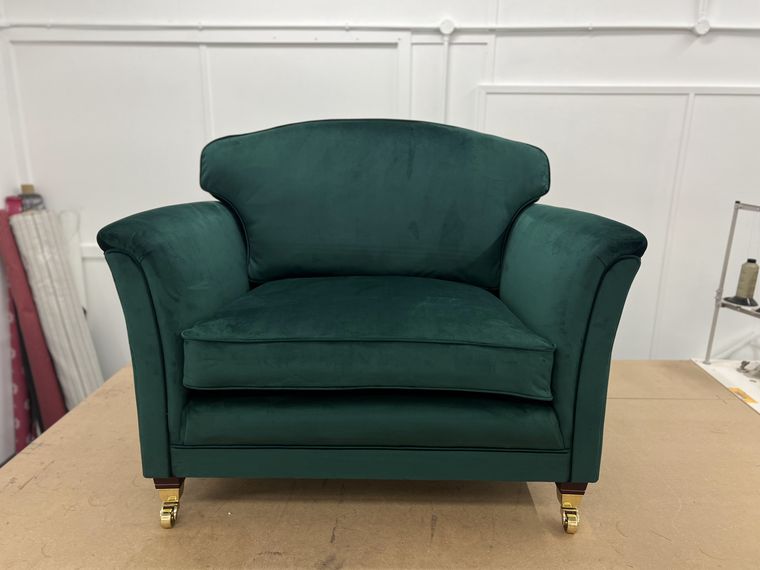 Love-seat armchair in emerald velvet.