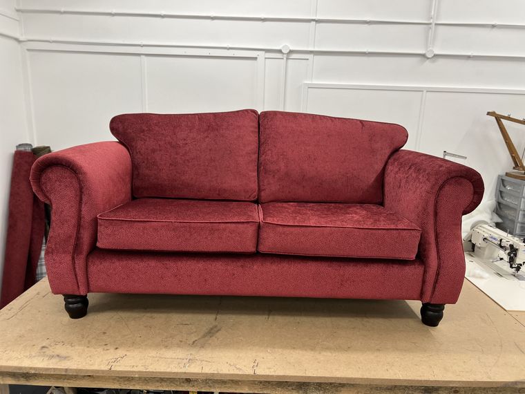 Two-seater scroll-arm sofa in raspberry.