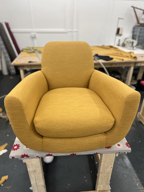 Curved tub chair in ochre velvet.