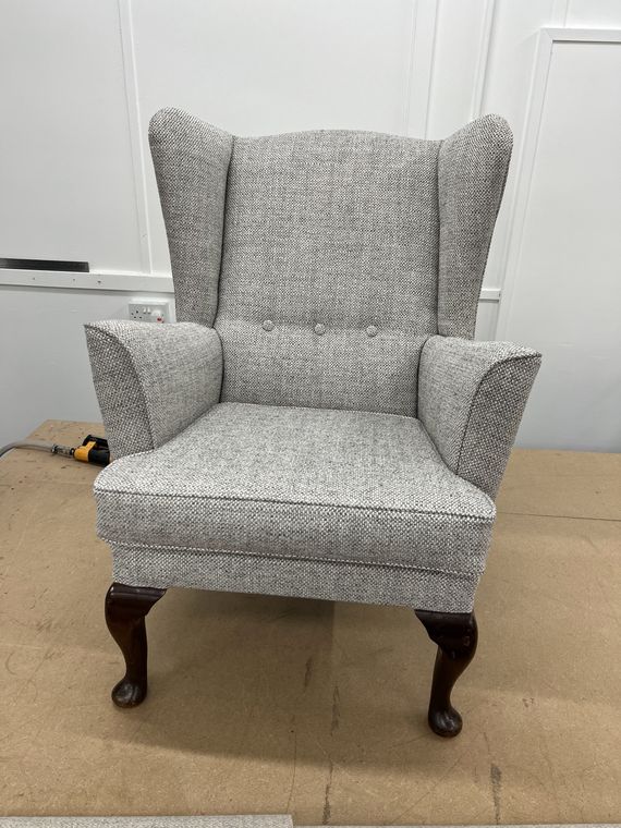 Wing-back armchair in grey herringbone.