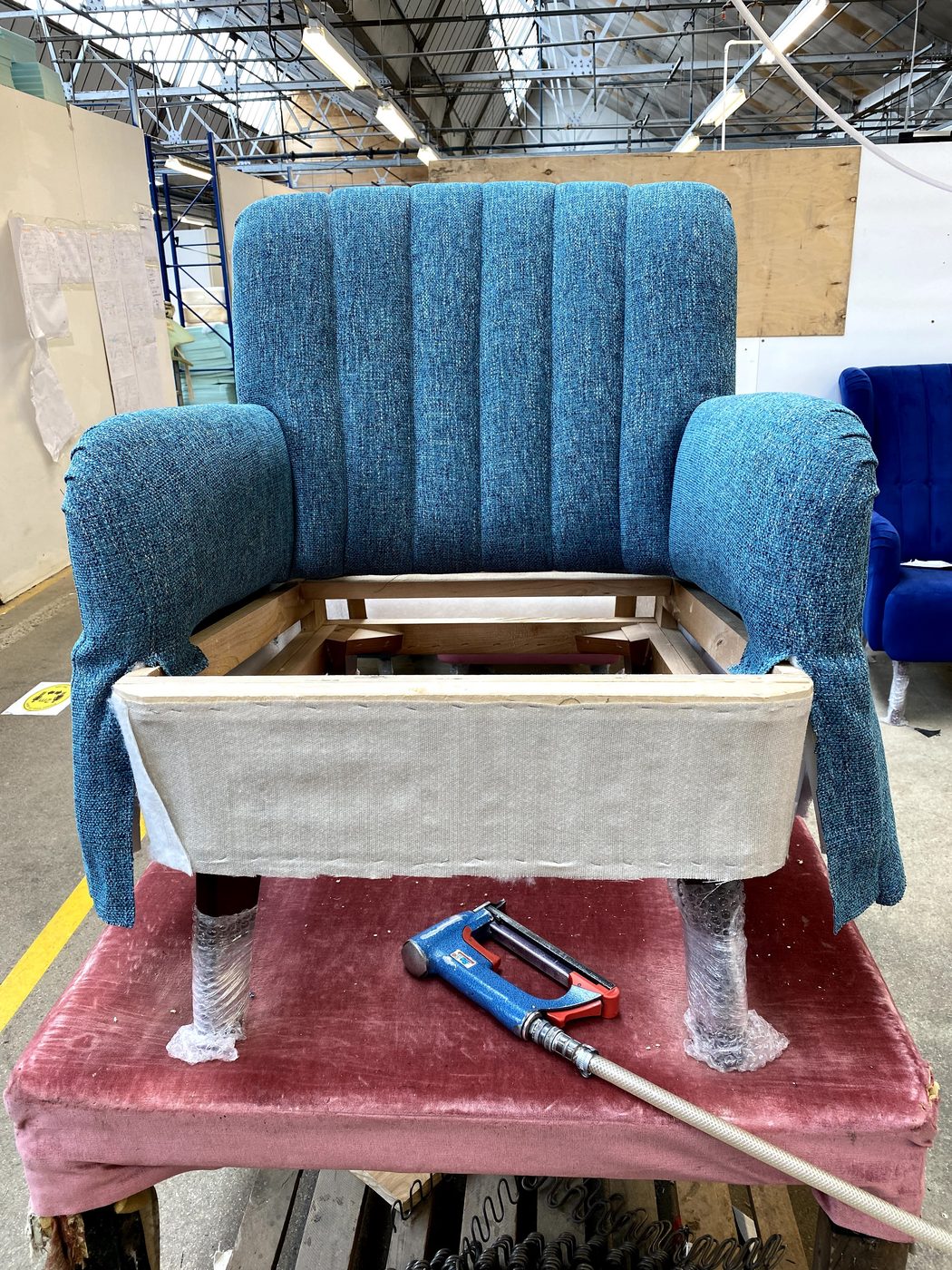 The chair's signature: the fluted inside back going on over an elastic-webbed frame, every channel running plumb.
