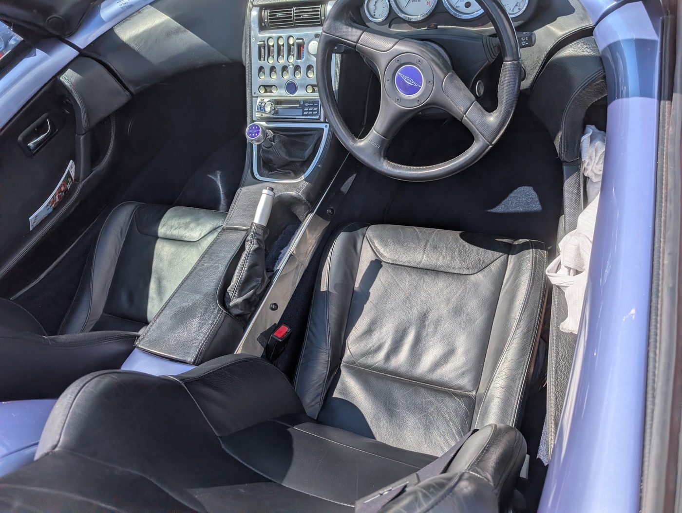 Both footwells, the tunnel and the console surround — one continuous run of navy.