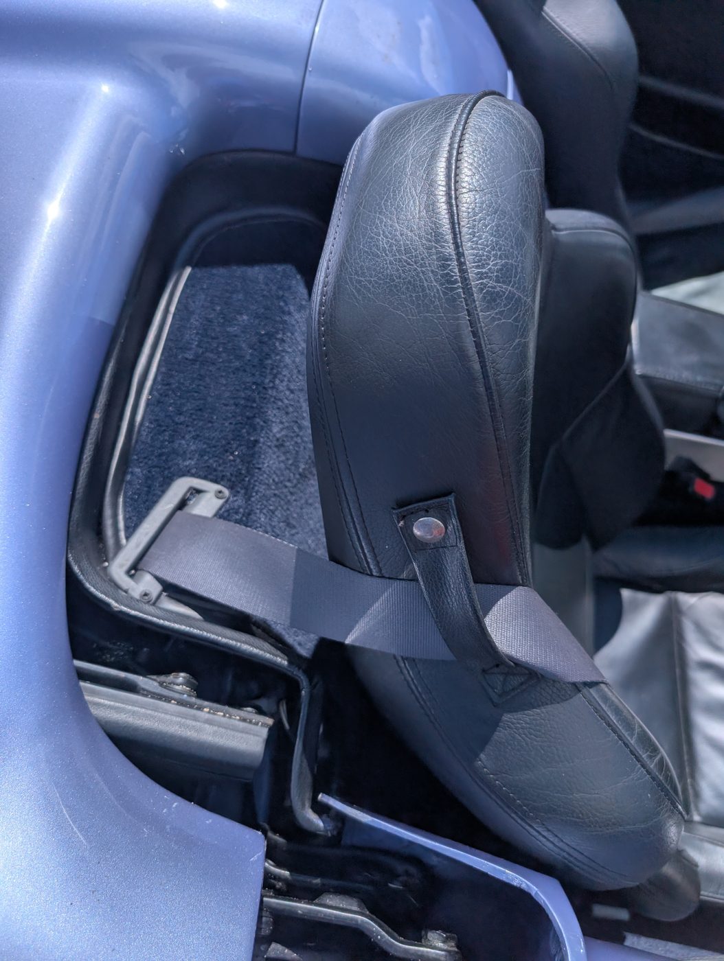 The seat refitted, belt anchored, and the carpet running cleanly under the runners and up to the sill.