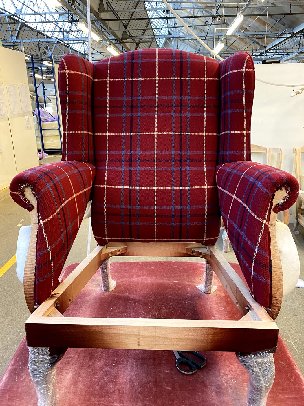 The inside back on — supported on elastic webbing behind, with the verticals of the check running plumb up the chair.