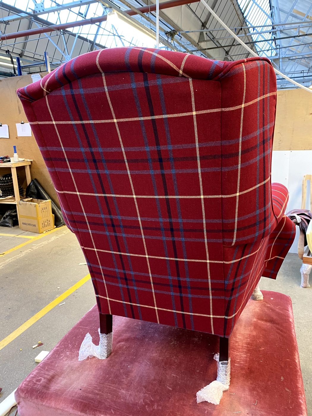 The outside arms closed in, the check still running true around the outside of the chair.
