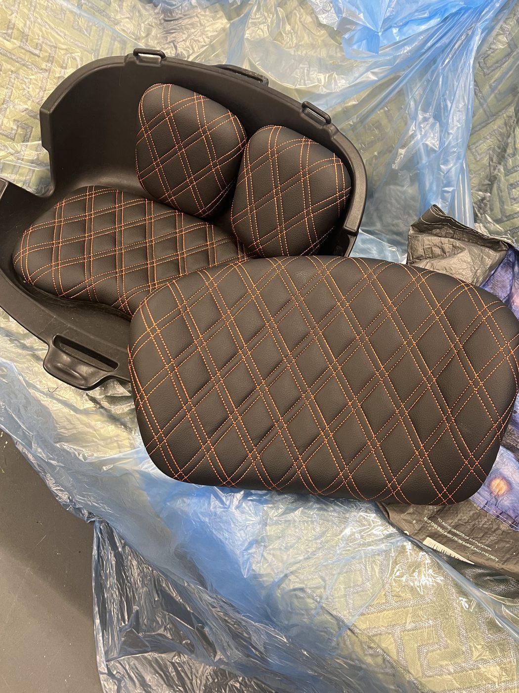 The pads in their new skin — double-diamond quilted vinyl, orange stitching.